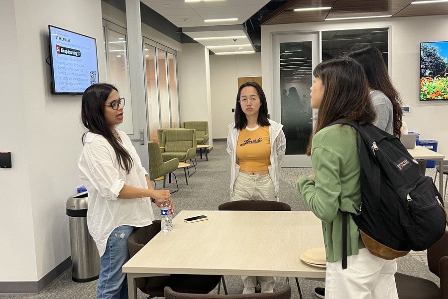 Students speaking with iSchool staff during a career event.