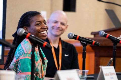 Two panelists smiling with microphones