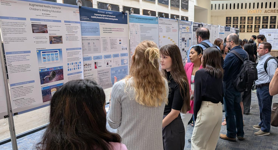 Students and guests moving through a previous iSchool capstone poster showcase.