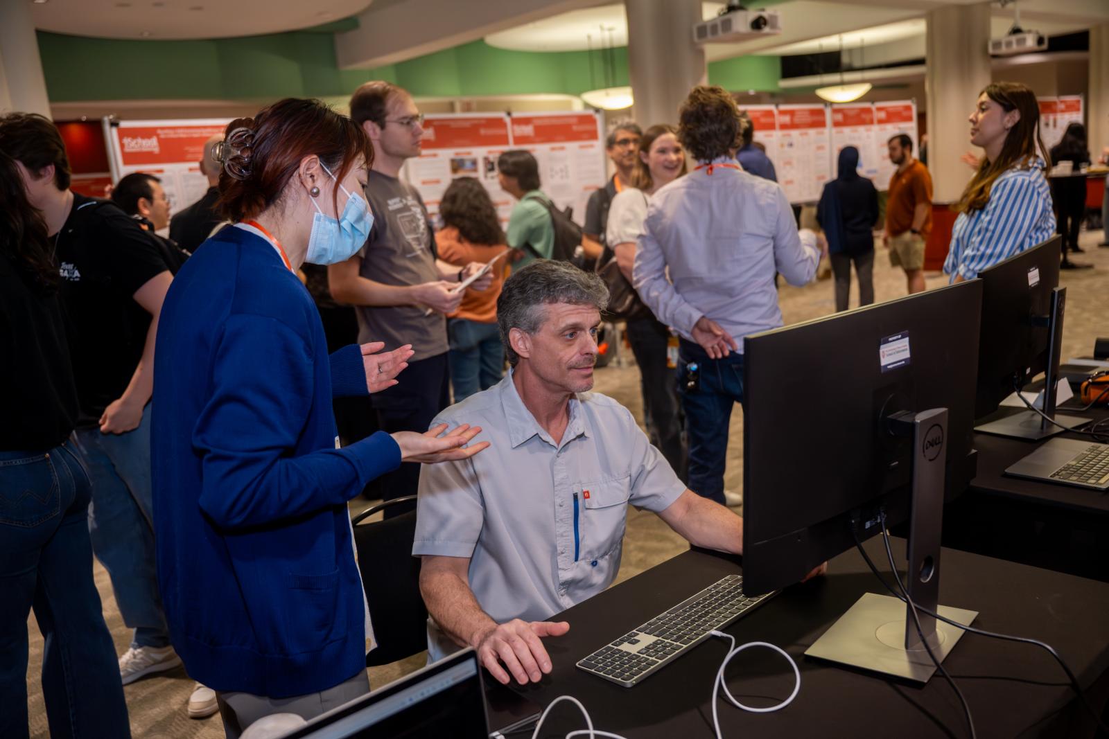 Researcher showing participant a demo on a large monitor