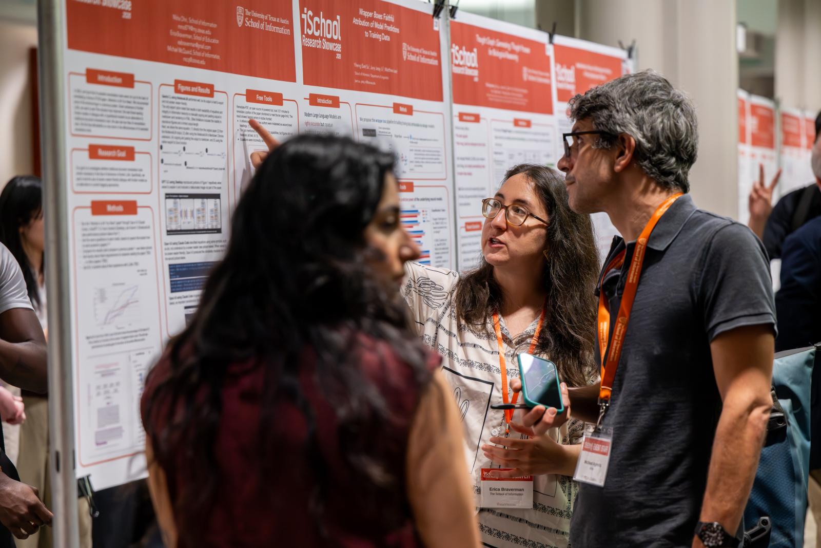 Researcher explaining poster to showcase attendee