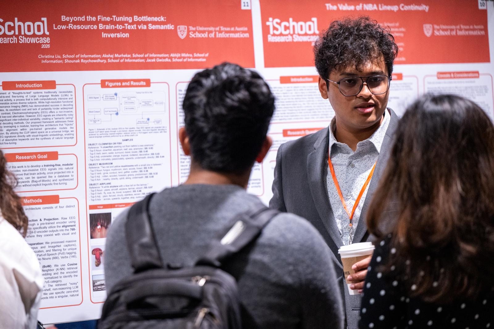 Researcher speaking to showcase attendees in front of poster