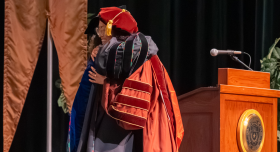 Min Kyung Lee and Angie Zhang embrace at commencement