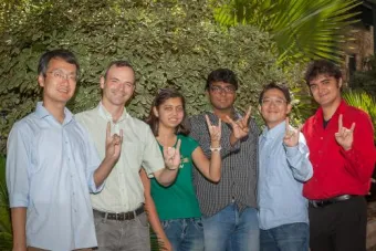 Lab members standing and doing the longhorn hook em' signal