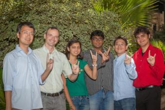Lab members standing and doing the longhorn hook em' signal