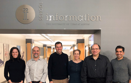 Faculty members Danna Gurari, Ed Cutrell, Roy Zimmermann, Meredith Morris, Ken Fleischmann, and Neel Joshi standing together at the interior entrance to the iSchool